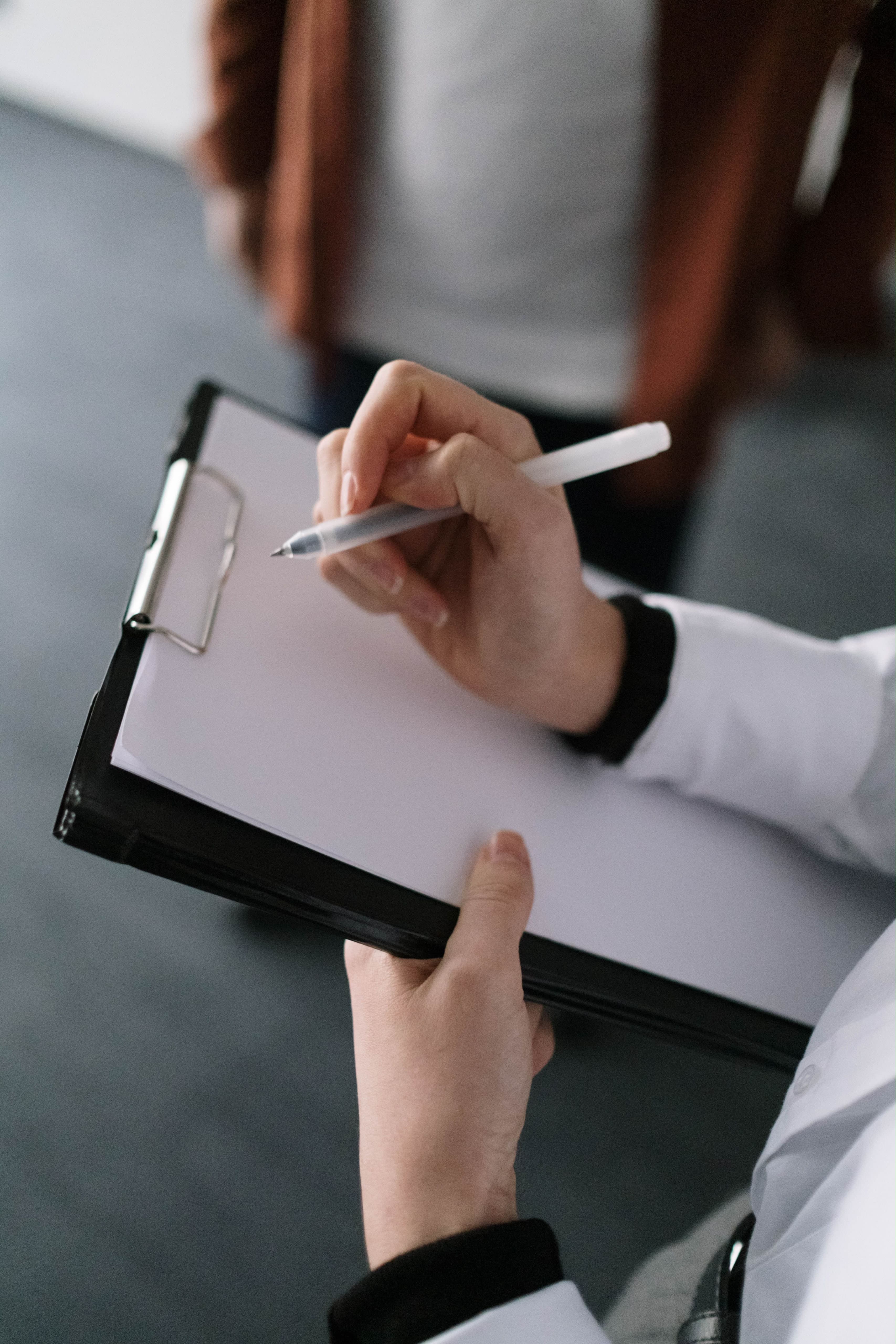 Profesional tomando notas durante una consulta